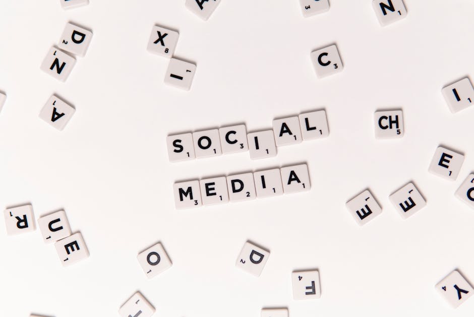 Flat lay of letter tiles spelling Social Media with scattered white tiles on a surface