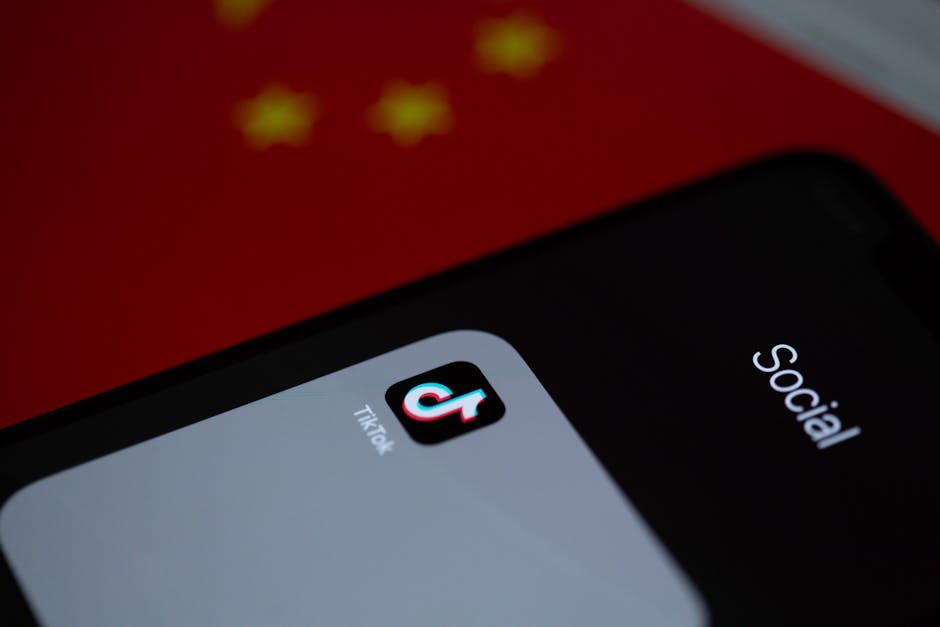 Close-up of TikTok app icon on a smartphone, set against a Chinese flag background